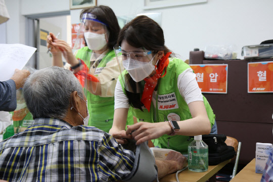 지난 7일 전라남도 여수로 의료봉사활동을 떠난 제주항공과 열린의사회 자원봉사자들이 주민들의 건강상태를 살피고 있다. <제주항공 제공>